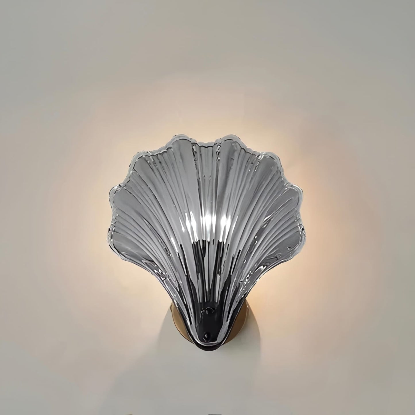 "Elegant shell-shaped wall sconce with warm LED glow, crafted from glass, enhances decor with seaside charm for home lighting