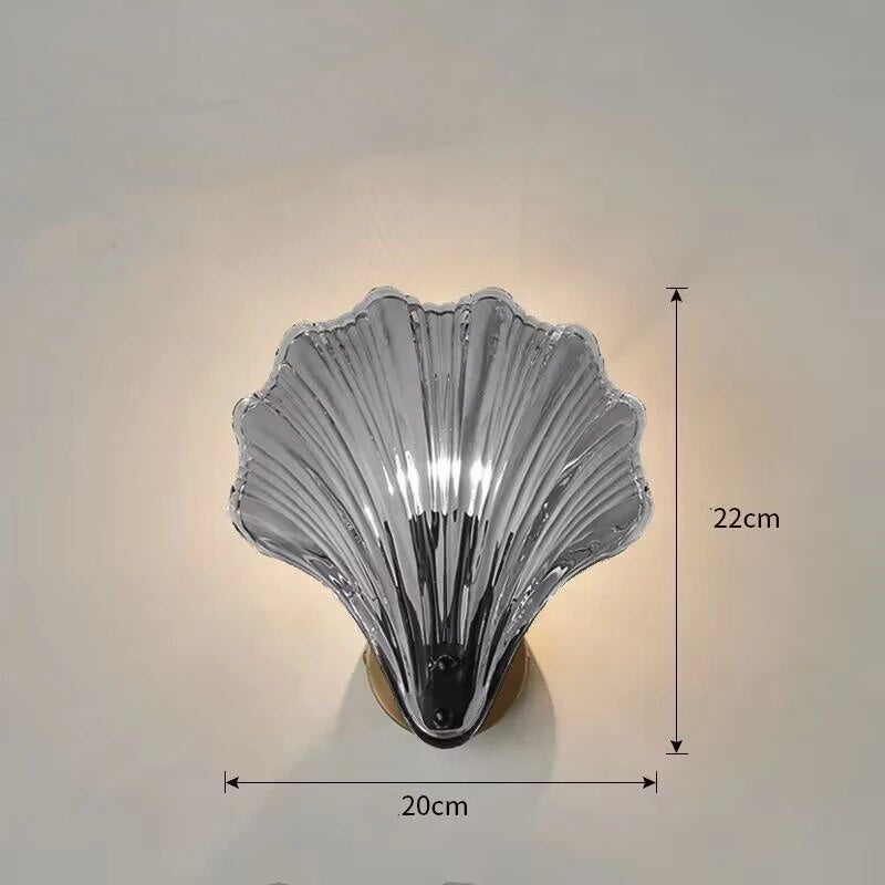 "Elegant shell-shaped wall sconce with warm LED glow, crafted from glass, enhances decor with seaside charm for home lighting