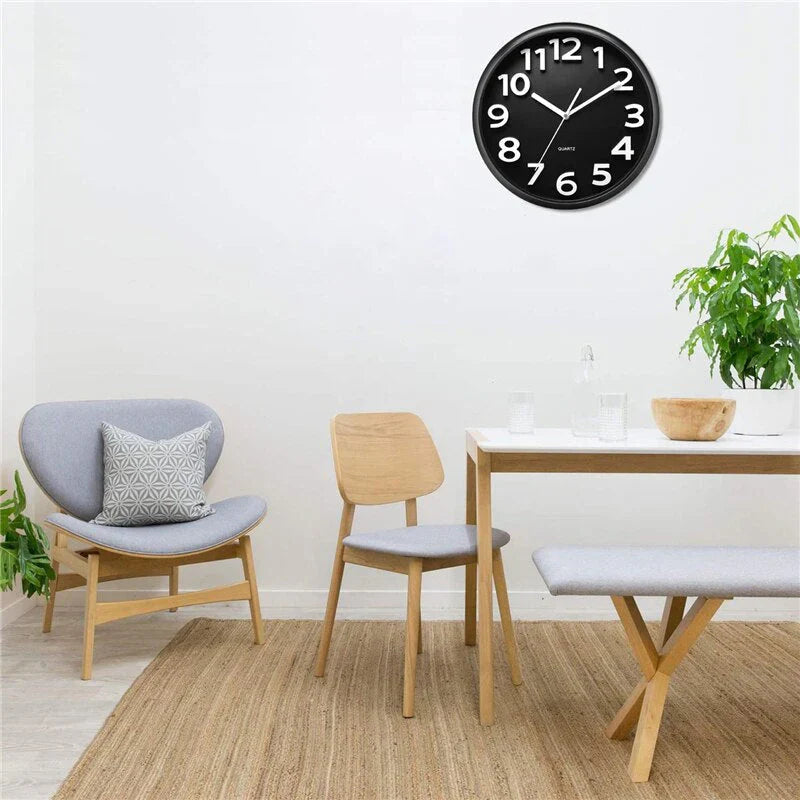 Modern minimalist wall clock with sleek black rim and silent operation, enhancing any room with its sophisticated design.