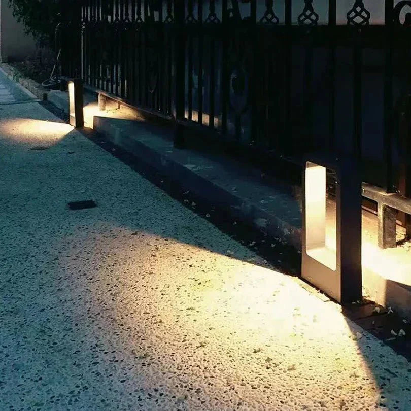 "Sleek waterproof outdoor LED garden light illuminating garden paths, robust aluminum build with modern minimalist design."