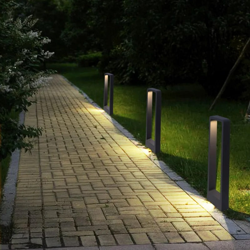 "Sleek waterproof outdoor LED garden light illuminating garden paths, robust aluminum build with modern minimalist design."